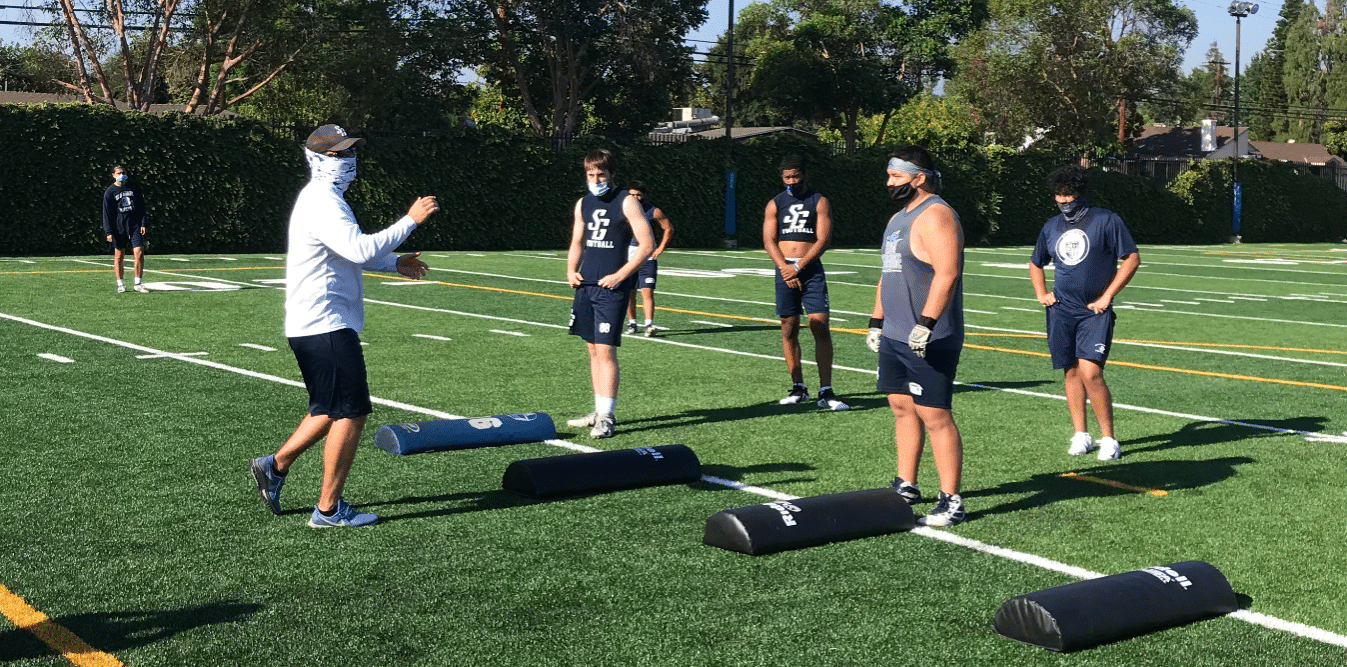 Assistant coach leads a “pod” of six football players in a drill