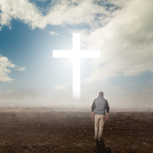 man walks towards Cross