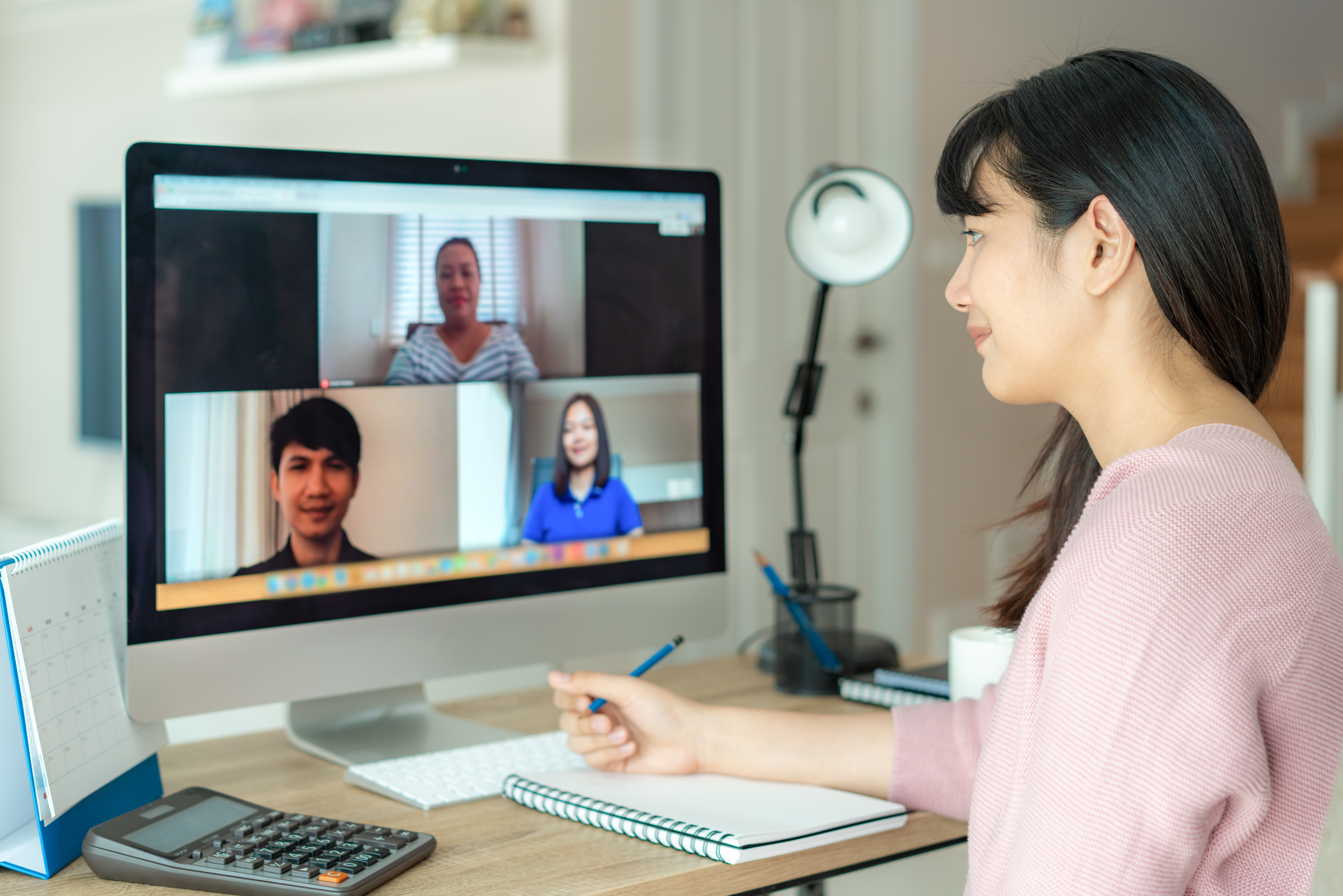 woman talking to her colleagues through video conference