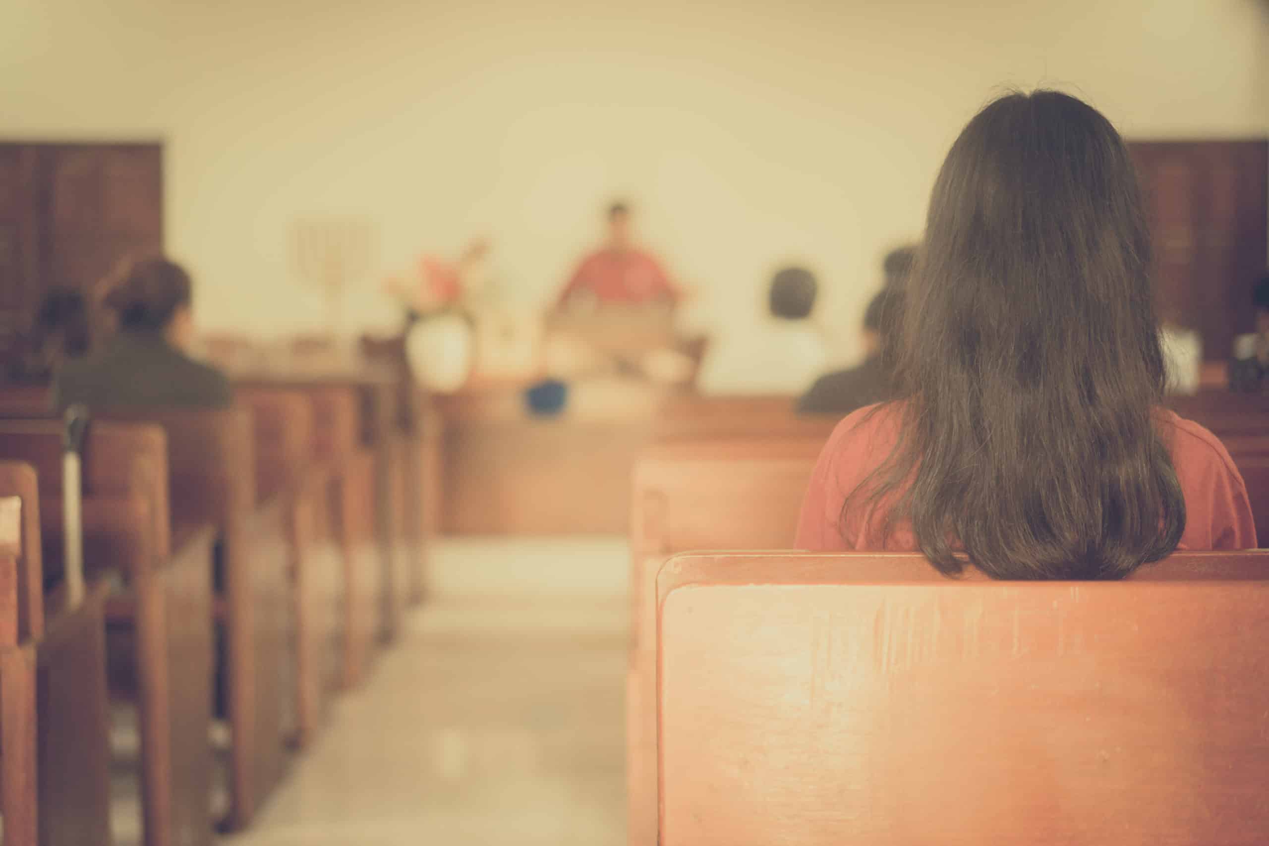 back of a woman sitting inside church
