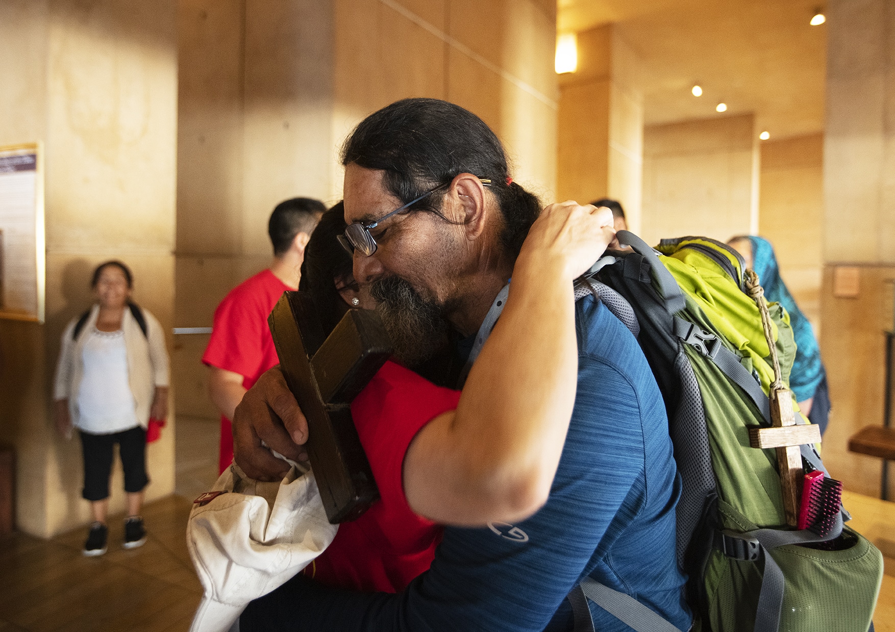 man and woman hug during the Immigration Mass