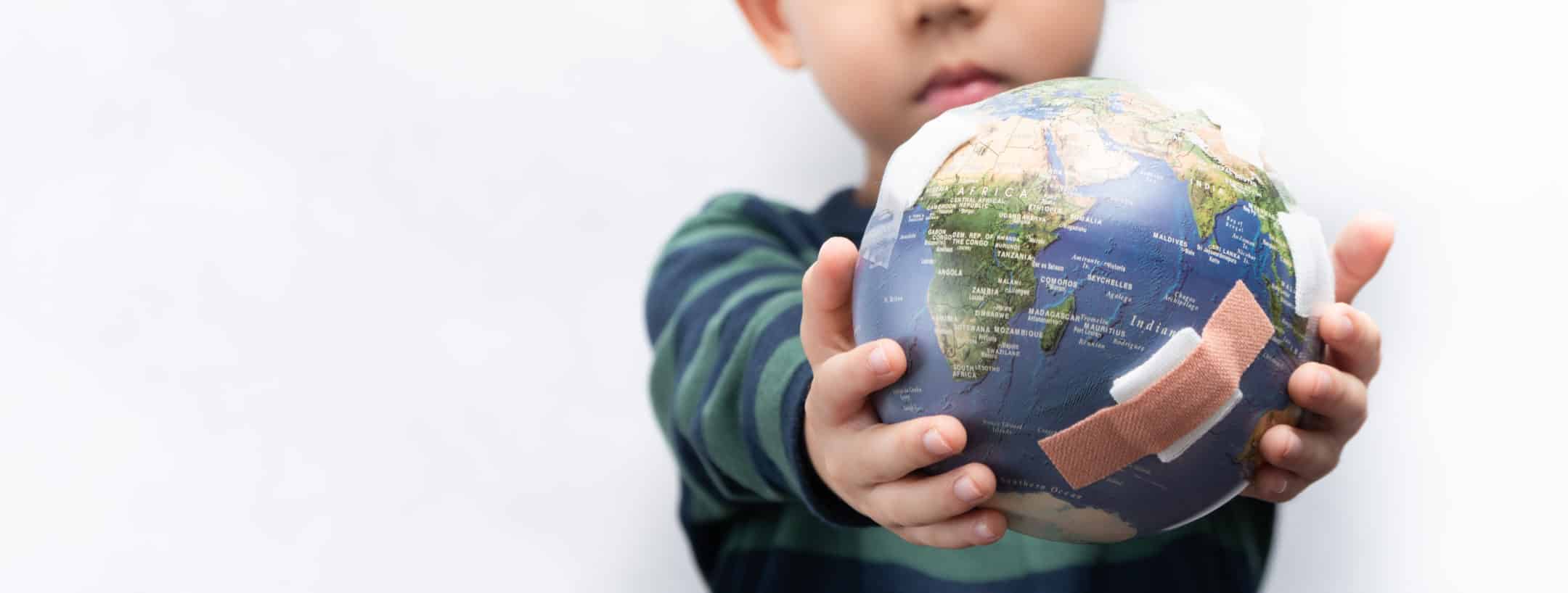 child holding a globe in his hands