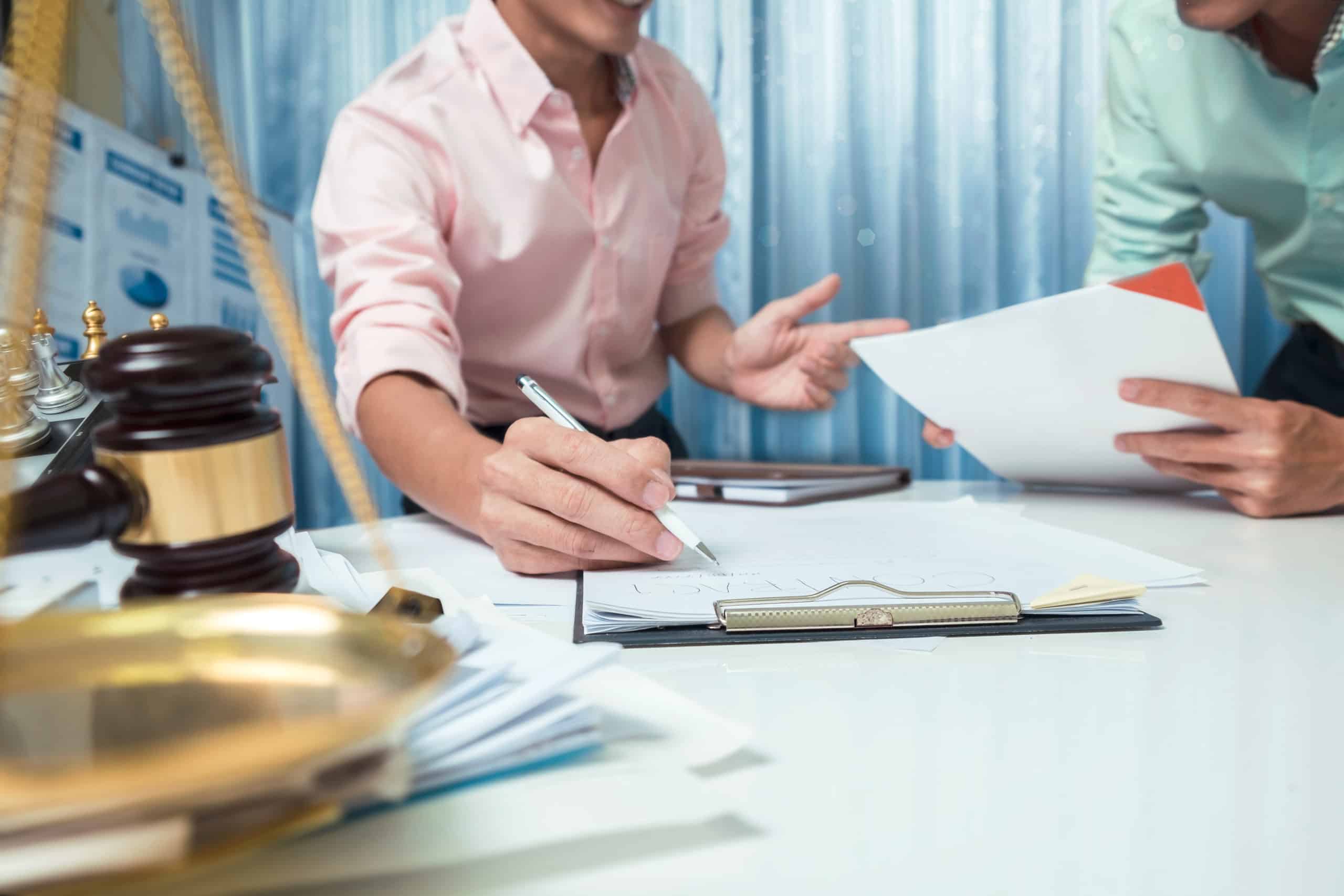 a man is helping another man fill out paperwork