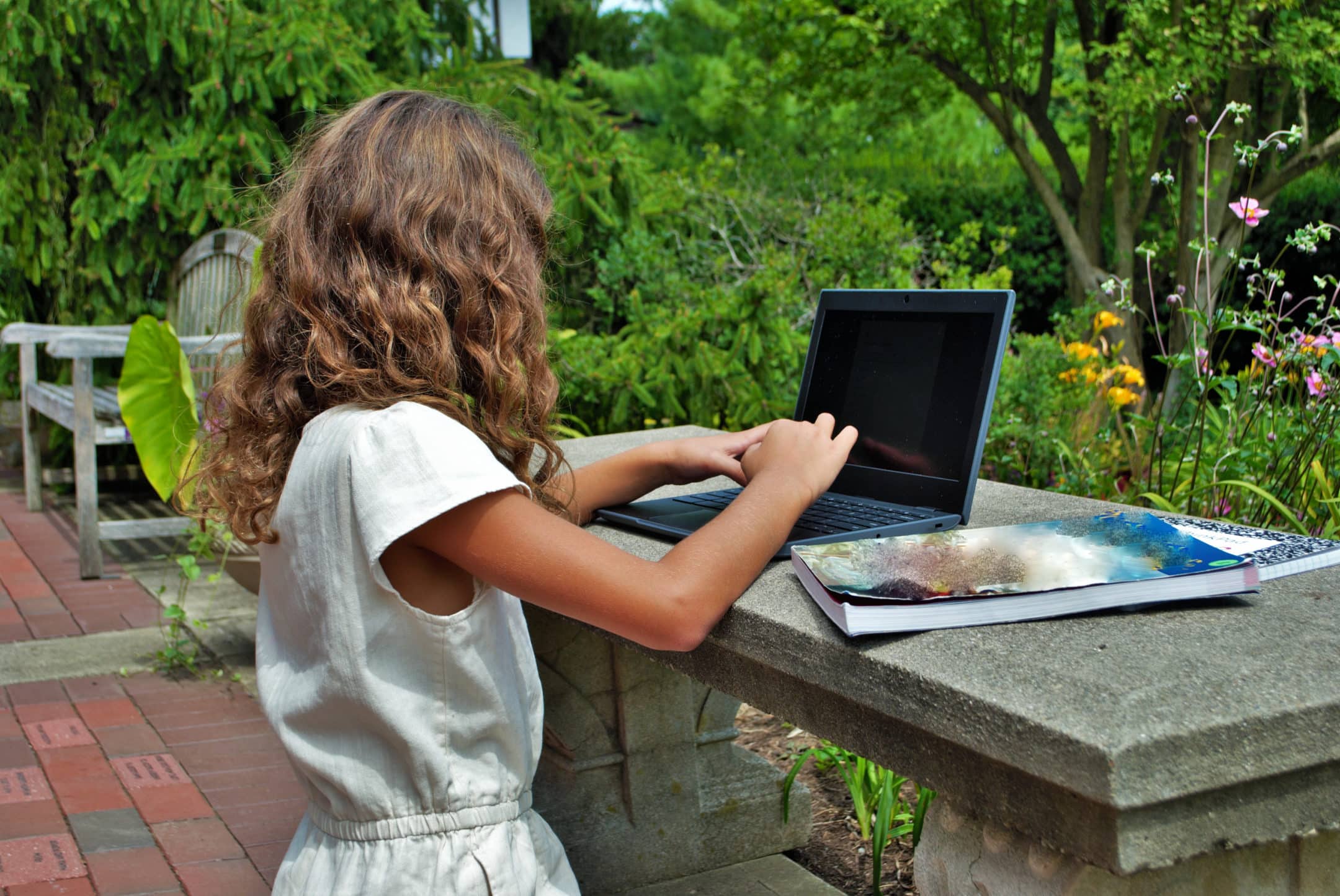 young girl in the park doing remote learning classes