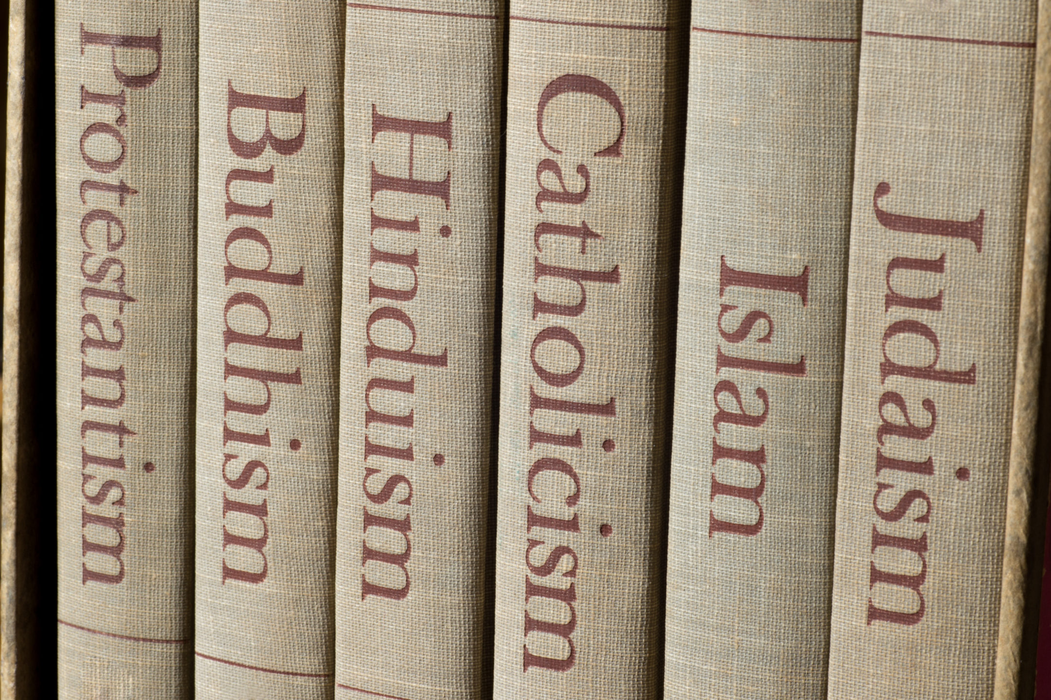 Book spines listing major world religions