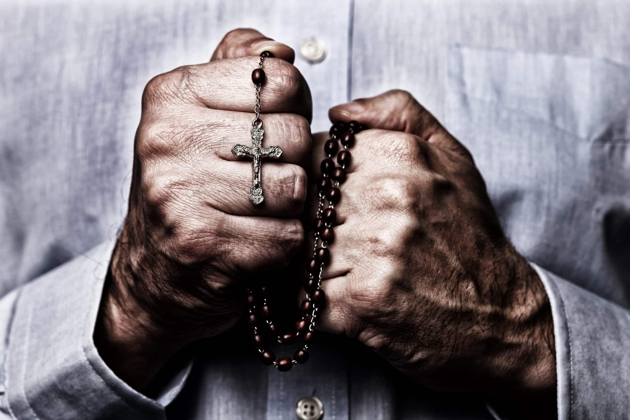 Hands enclosing a rosary