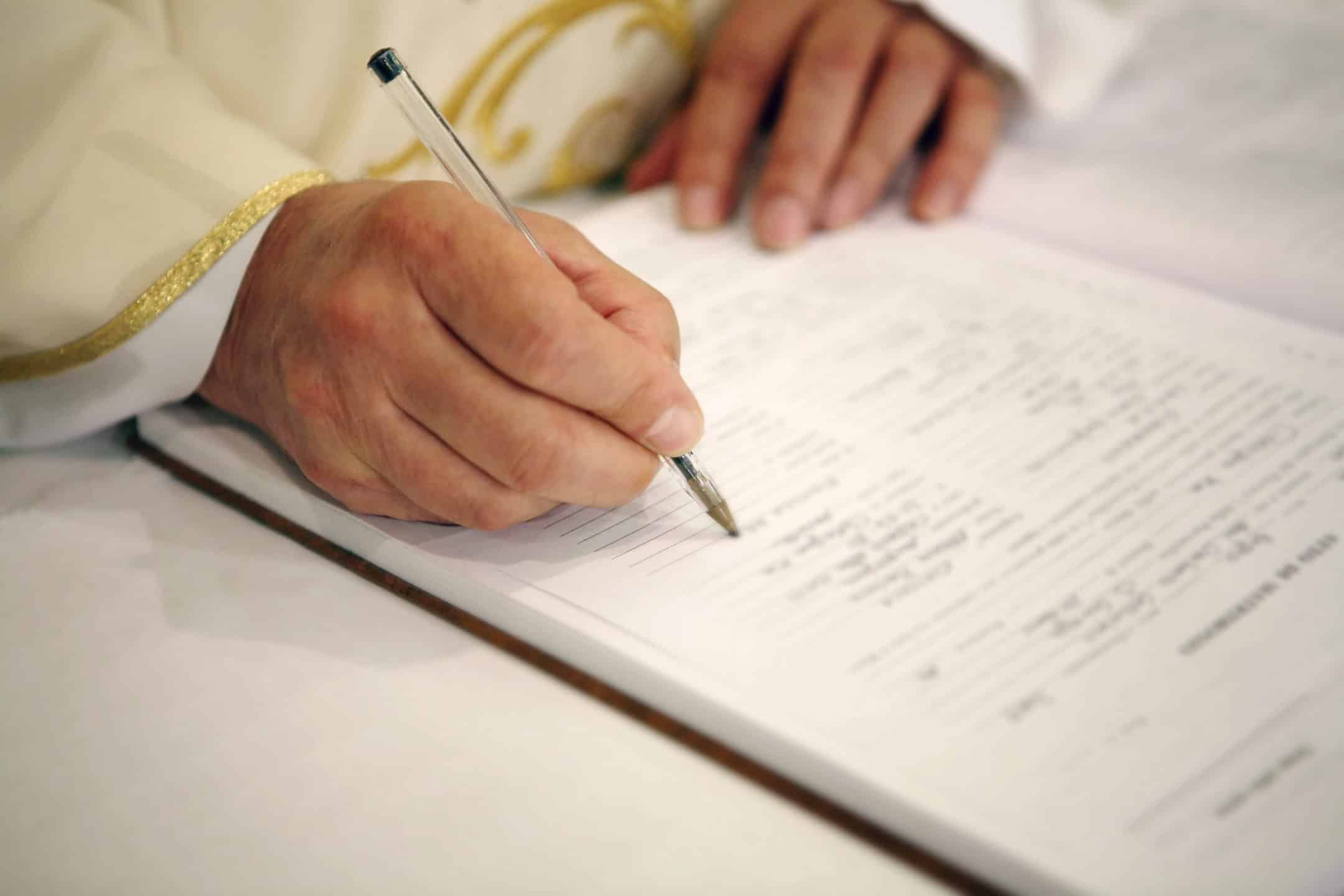 Priest signing the marriage register