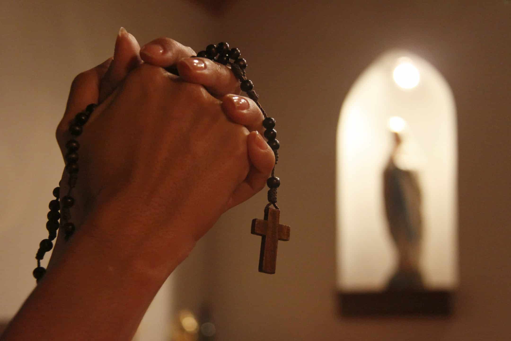 hands holding rosary praying
