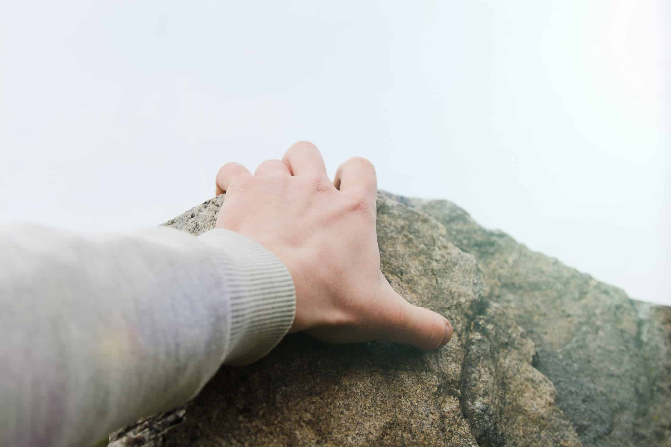 Rock Climbers hand grasping a cliff